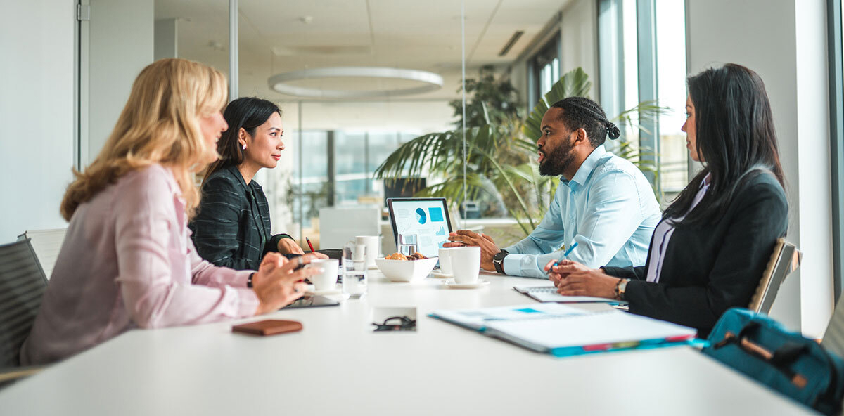 Diverse group of colleagues discussing data during a meeting